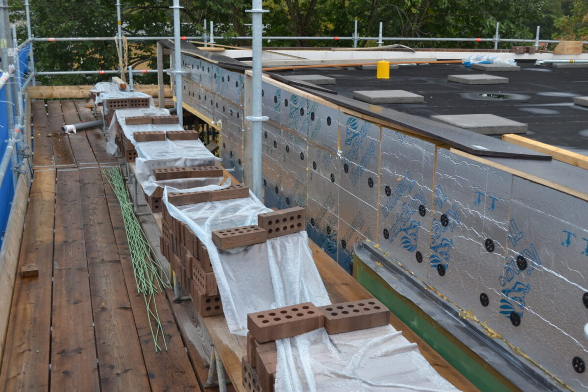 In het geval van een gemetselde dakrandoplossing is er vaak sprake van een vrij op het dak staande, lage spouwmuur.