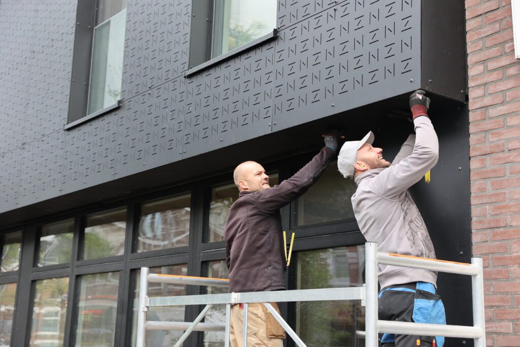 monteren gevelplaten op een biobased en passiefgebouw in Rotterdam.