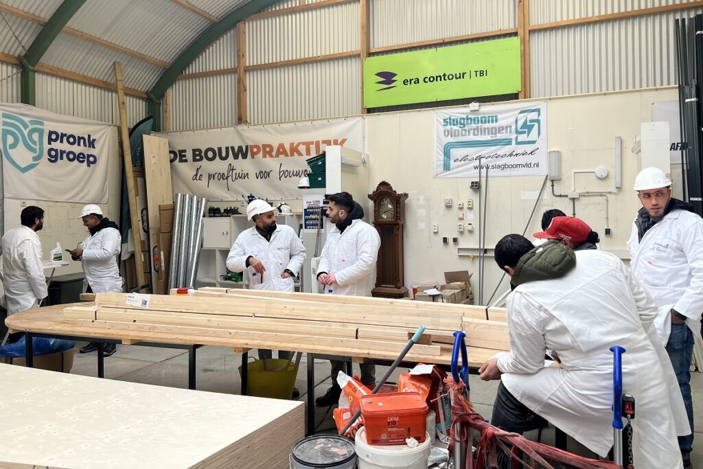 Deelnemers aan De Bouwpraktijk leren timmeren.