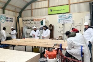 Deelnemers aan De Bouwpraktijk leren timmeren.